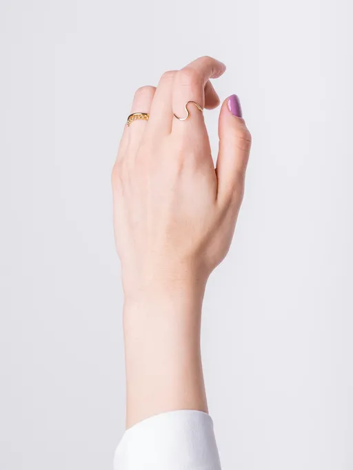 Hand model posing against a light studio backdrop