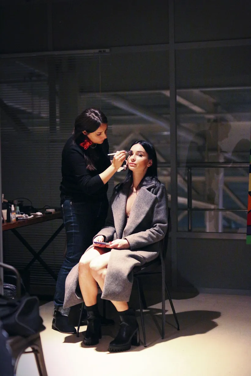 Make-up artist preparing a model backstage